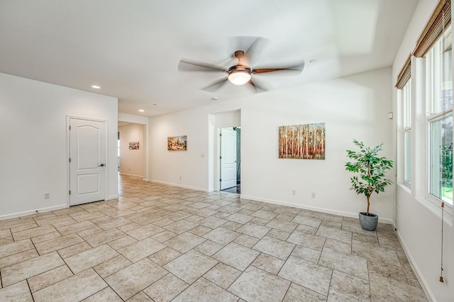 unfurnished room with a ceiling fan, recessed lighting, baseboards, and light stone finish floors