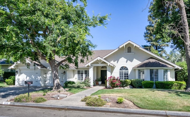 view of front of home featuring a garage, a front yard, and driveway