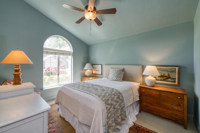 bedroom with light colored carpet, lofted ceiling, a ceiling fan, and baseboards