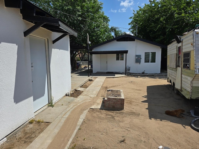 rear view of house featuring stucco siding and a patio