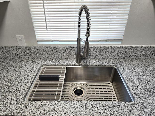 kitchen view of a sink and stone countertops