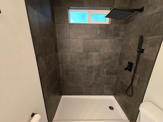 full bathroom with toilet and a tile shower