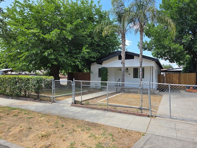 view of front of home featuring a gate, a fenced front yard, and stucco siding
