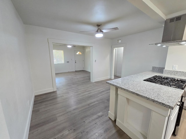 kitchen featuring light wood-type flooring, ceiling fan, baseboards, white cabinetry, and gas stove