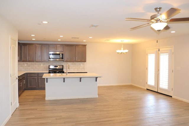 1884 Clover, Dinuba, CA 93618 - kitchen with appliances with stainless steel finishes, light countertops, decorative backsplash, light wood-style flooring, and a ceiling fan