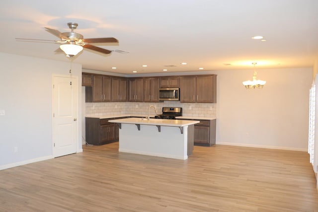 1884 Clover, Dinuba, CA 93618 - kitchen with stainless steel microwave, gas range, a chandelier, backsplash, and recessed lighting