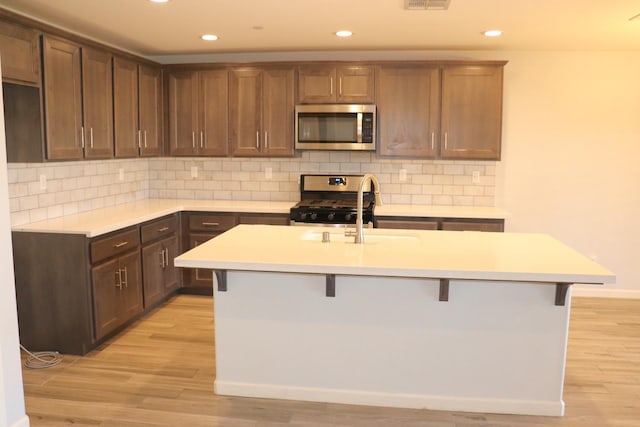 1884 Clover, Dinuba, CA 93618 - kitchen featuring stainless steel appliances, a sink, light wood-style flooring, a kitchen bar, and recessed lighting