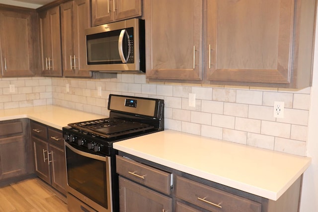 1884 Clover, Dinuba, CA 93618 - kitchen with appliances with stainless steel finishes, light countertops, tasteful backsplash, and light wood-style floors