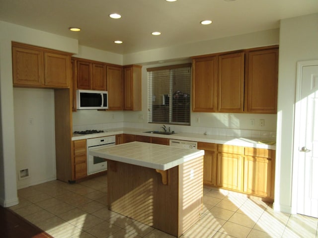 1016 Papaya St, Madera, CA 93638 - kitchen with white appliances, tile counters, a center island, a sink, and light tile patterned flooring