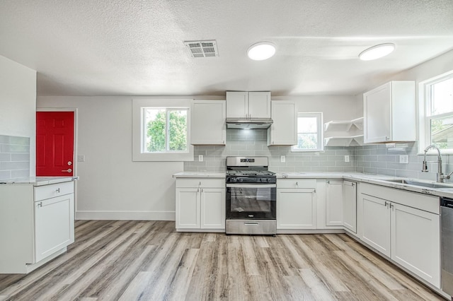 604 N Poplar Ave, Fresno, CA 93728 - kitchen with appliances with stainless steel finishes, a sink, light countertops, light wood-type flooring, and white cabinets
