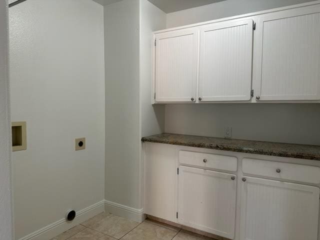 10752 N Windham Bay Cir, Fresno, CA 93730 - washroom with electric dryer hookup, light tile patterned floors, baseboards, and cabinet space
