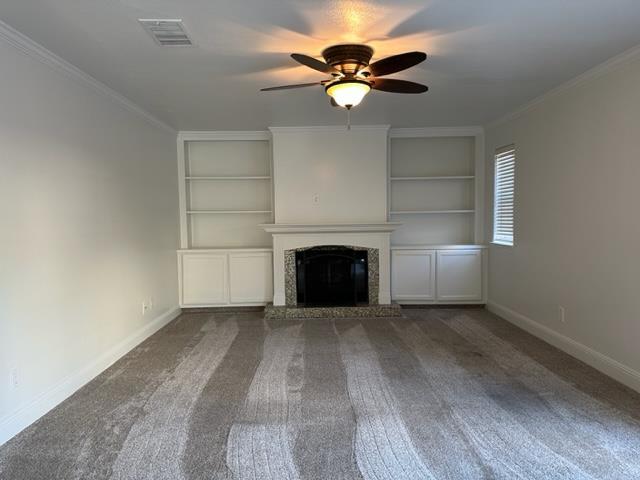 10752 N Windham Bay Cir, Fresno, CA 93730 - unfurnished living room with built in features, baseboards, ceiling fan, carpet flooring, and crown molding