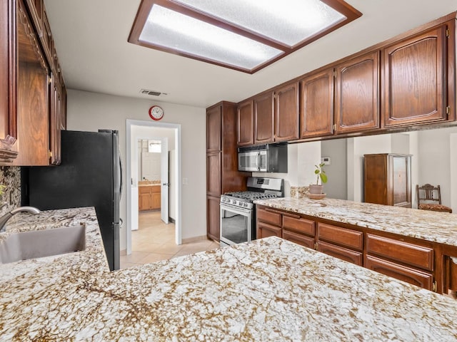 12502 Rd 37 Unit 1/2, Madera, CA 93636 - kitchen featuring appliances with stainless steel finishes, light tile patterned floors, a sink, and light stone countertops