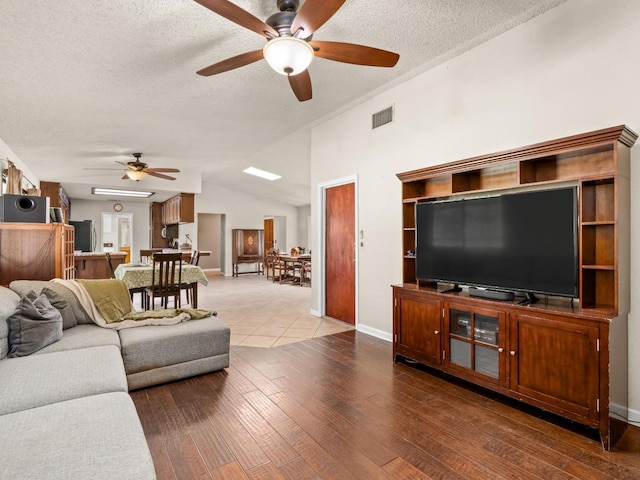 12502 Rd 37 Unit 1/2, Madera, CA 93636 - living area featuring a ceiling fan, vaulted ceiling, hardwood / wood-style floors, a textured ceiling, and baseboards