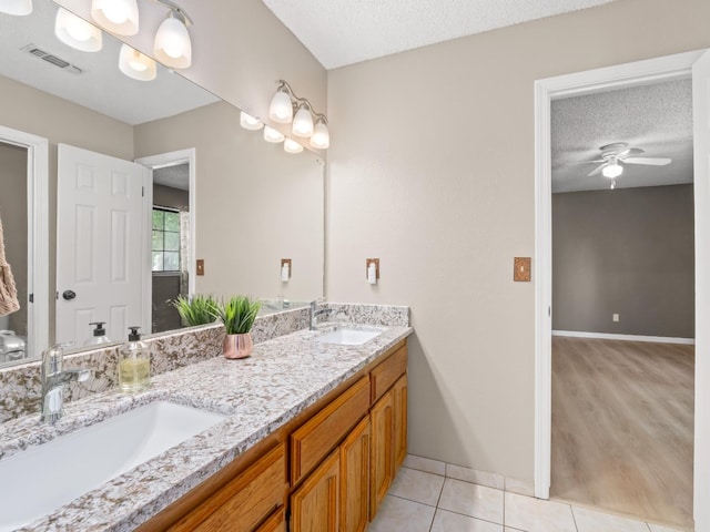 12502 Rd 37 Unit 1/2, Madera, CA 93636 - bathroom with ceiling fan, a textured ceiling, double vanity, tile patterned flooring, and baseboards