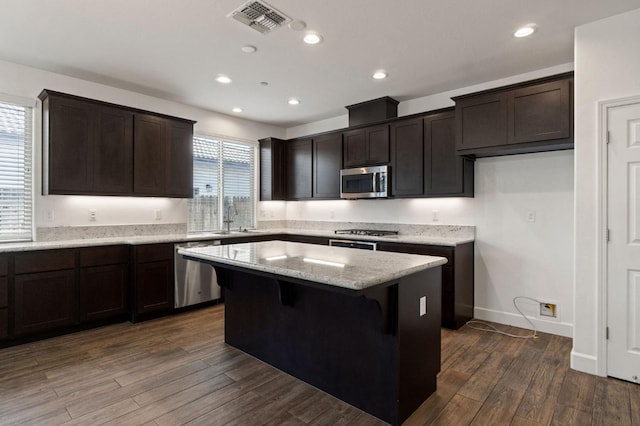3822 Hannah Ln, Clovis, CA 93619 - kitchen featuring appliances with stainless steel finishes, a center island, dark brown cabinets, dark wood-type flooring, and recessed lighting