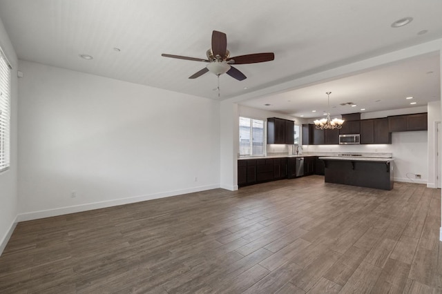 3822 Hannah Ln, Clovis, CA 93619 - unfurnished living room featuring a chandelier, dark wood-style flooring, a ceiling fan, baseboards, and recessed lighting
