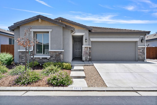 3822 Hannah Ln, Clovis, CA 93619 - view of front of house featuring stone siding, a garage, driveway, and stucco siding