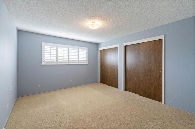 1322 W Millbrae Ave, Fresno, CA 93711 - unfurnished bedroom with multiple closets, carpet floors, and a textured ceiling
