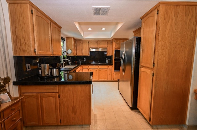 6340 N Gilroy Ave, Fresno, CA 93722 - kitchen featuring black appliances, a raised ceiling, a sink, a peninsula, and decorative backsplash