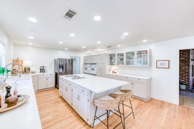 5669 N Arthur Ave, Fresno, CA 93711 - kitchen featuring a sink, white appliances, a kitchen island, light wood-type flooring, and recessed lighting