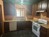 1212 Phillip St, Madera, CA 93638 - kitchen with white range with gas cooktop, under cabinet range hood, light countertops, and a sink