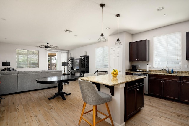 2326 W Flagstaff, Visalia, CA 93291 - kitchen featuring stainless steel dishwasher, a sink, open floor plan, a breakfast bar area, and light wood-type flooring