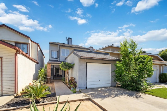 3591 W Harvard Ave, Fresno, CA 93722 - view of front of house featuring an attached garage, concrete driveway, stucco siding, and a chimney