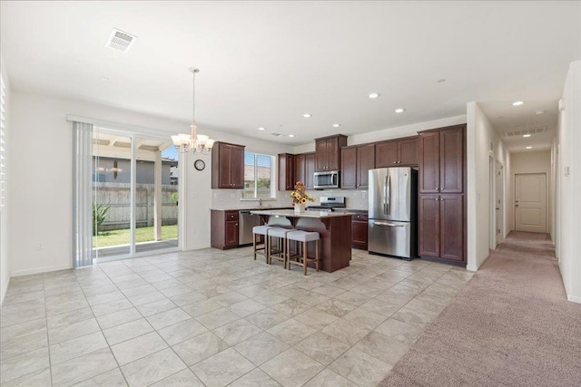 1799 Bolton Ave, Tulare, CA 93274 - kitchen with stainless steel appliances, a chandelier, a kitchen breakfast bar, a center island, and light countertops