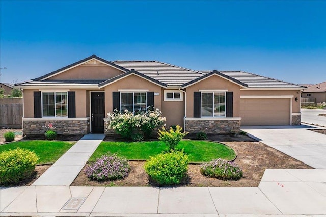 1799 Bolton Ave, Tulare, CA 93274 - ranch-style house featuring stone siding, stucco siding, an attached garage, driveway, and a tile roof