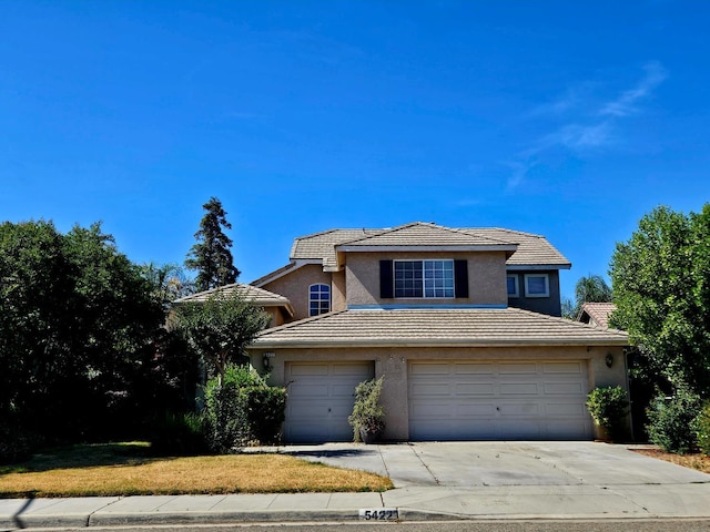 5422 W Calimyrna Ave, Fresno, CA 93722 - traditional home with stucco siding, a tile roof, concrete driveway, an attached garage, and a front lawn