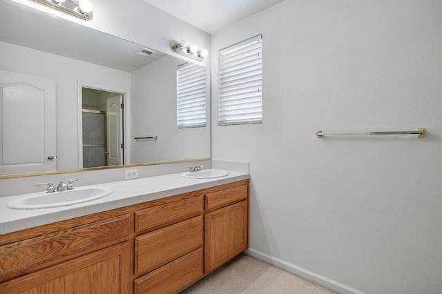 5422 W Calimyrna Ave, Fresno, CA 93722 - bathroom with double vanity, an enclosed shower, and baseboards