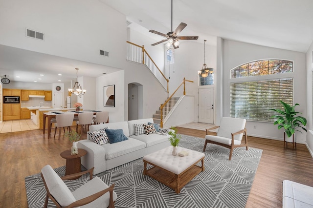 5422 W Calimyrna Ave, Fresno, CA 93722 - living area featuring a chandelier, light wood-type flooring, stairway, high vaulted ceiling, and recessed lighting