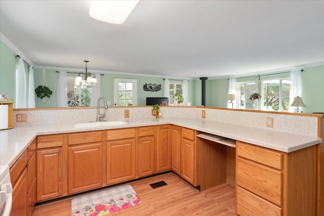 34133 Keller Rd, North Fork, CA 93643 - kitchen with ornamental molding, light wood-type flooring, light countertops, a chandelier, and hanging light fixtures