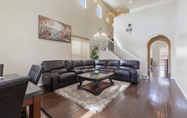 7026 E Dayton Ave, Fresno, CA 93737 - living area featuring a towering ceiling, arched walkways, stairway, dark wood-type flooring, and a chandelier