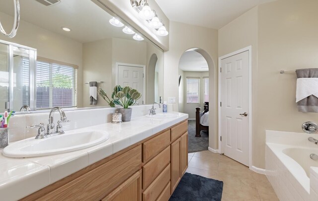 7026 E Dayton Ave, Fresno, CA 93737 - full bathroom featuring plenty of natural light, double vanity, a garden tub, and tile patterned floors