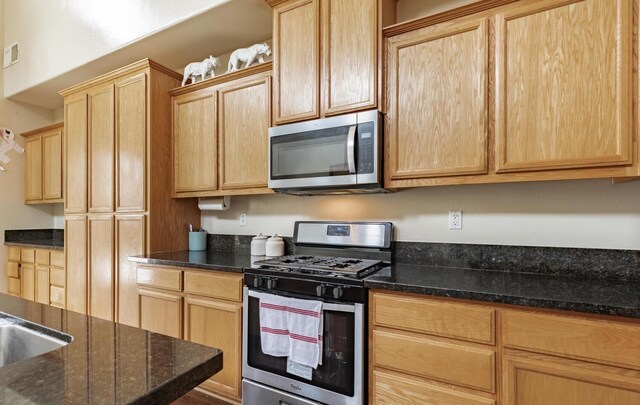 7026 E Dayton Ave, Fresno, CA 93737 - kitchen with appliances with stainless steel finishes, light brown cabinets, and dark stone countertops