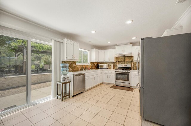 44719 Savage Rd, Coarsegold, CA 93614 - kitchen featuring stainless steel appliances, under cabinet range hood, white cabinets, tasteful backsplash, and light tile patterned floors