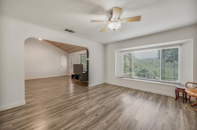 44719 Savage Rd, Coarsegold, CA 93614 - unfurnished living room with arched walkways, wood finished floors, vaulted ceiling, baseboards, and crown molding