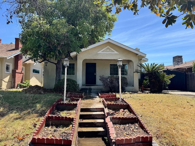 1382 N Thorne Ave, Fresno, CA 93728 - view of front facade with stucco siding, a vegetable garden, and covered porch