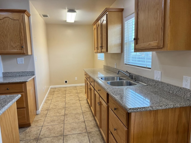 1382 N Thorne Ave, Fresno, CA 93728 - kitchen with a sink, baseboards, brown cabinets, and light tile patterned floors