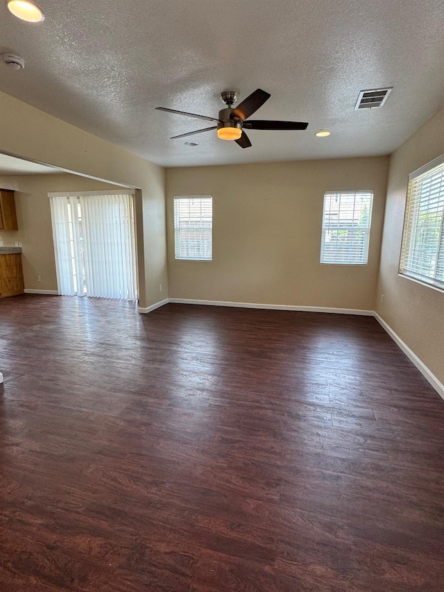 1382 N Thorne Ave, Fresno, CA 93728 - empty room featuring a textured ceiling, plenty of natural light, a ceiling fan, baseboards, and dark wood-type flooring
