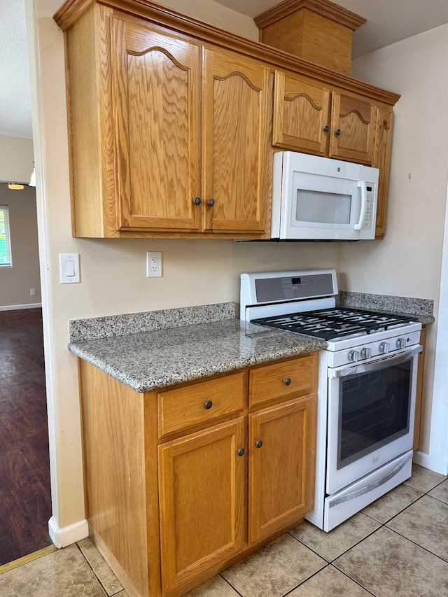 1382 N Thorne Ave, Fresno, CA 93728 - kitchen with white appliances, baseboards, light stone counters, and light tile patterned flooring