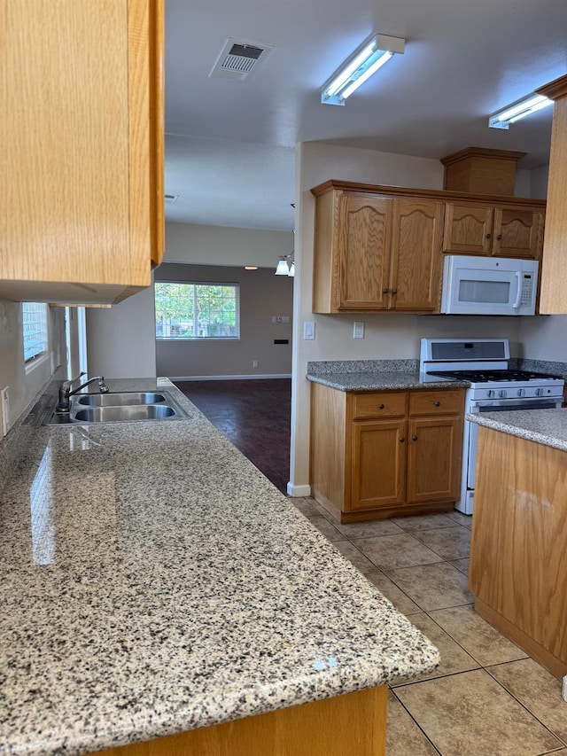 1382 N Thorne Ave, Fresno, CA 93728 - kitchen featuring white microwave, gas range oven, a sink, baseboards, and light stone countertops