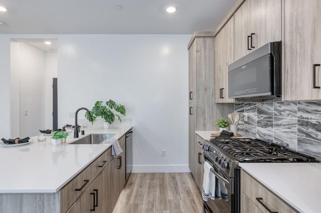 2867 E Tamarind Dr, Fresno, CA 93730 - kitchen featuring appliances with stainless steel finishes, a sink, light brown cabinetry, baseboards, and recessed lighting