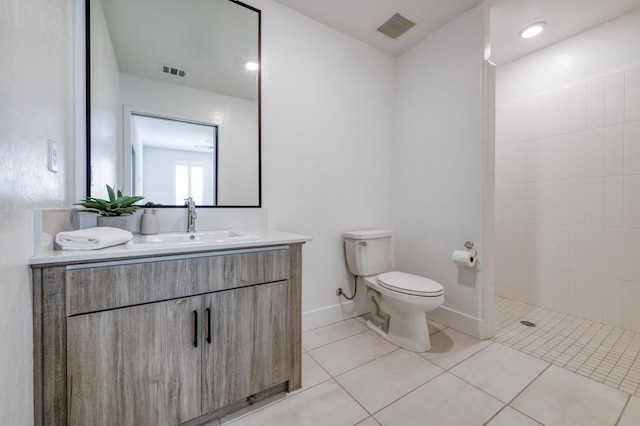 2867 E Tamarind Dr, Fresno, CA 93730 - bathroom featuring toilet, vanity, a tile shower, tile patterned floors, and baseboards