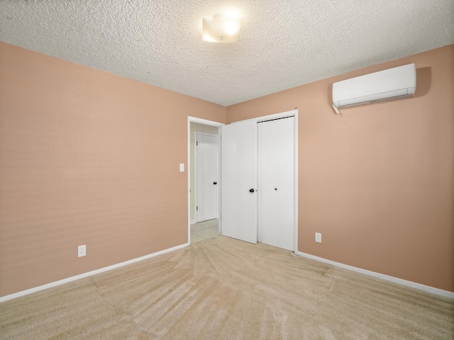 1646 W Millbrae Ave, Fresno, CA 93711 - unfurnished bedroom featuring a wall mounted AC, baseboards, a closet, carpet, and a textured ceiling