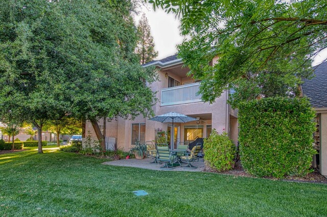 2895 W Kensington Ln, Fresno, CA 93711 - rear view of house featuring a balcony, stucco siding, a lawn, and a patio