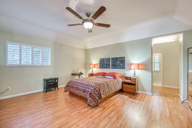 2895 W Kensington Ln, Fresno, CA 93711 - bedroom featuring light wood-style flooring, a wood stove, baseboards, and ceiling fan