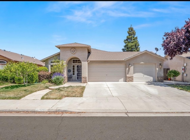 1656 N Cecelia Ave, Fresno, CA 93722 - view of front of home featuring an attached garage, stucco siding, stone siding, and driveway